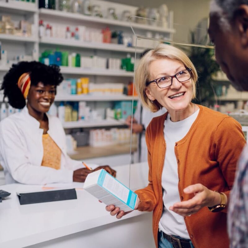 Woman speaks with man at pharmacy