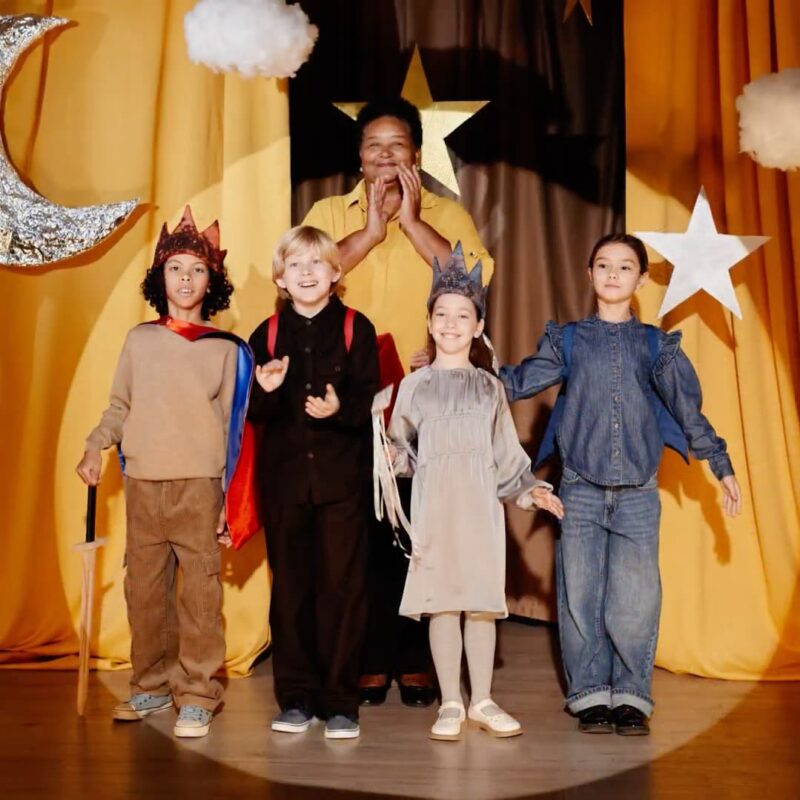 Teacher and Kids on stage after a play