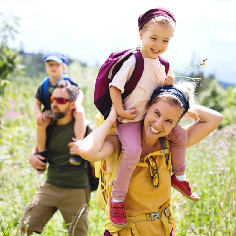 Family hikes together through a field