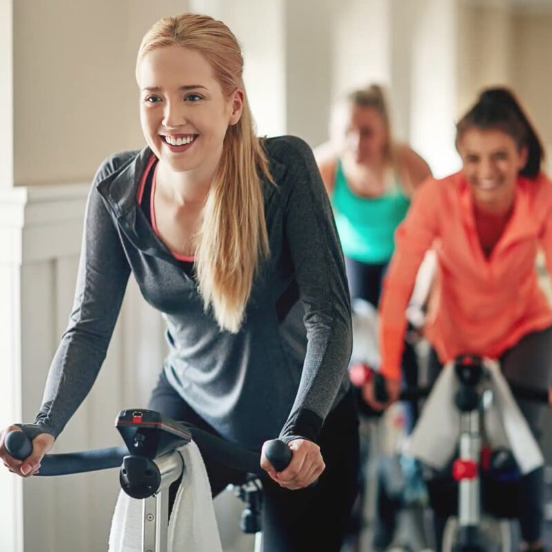 Woman rides stationary bike in class
